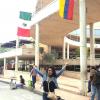 Mizraim en las afueras de un edificio en el que ondean las banderas de México y Colombia